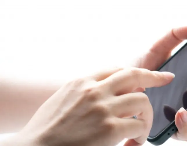 写真：スマホを打つ女の人の指