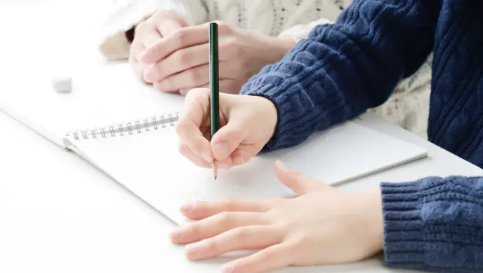 写真：男の子に家庭教師が教えている