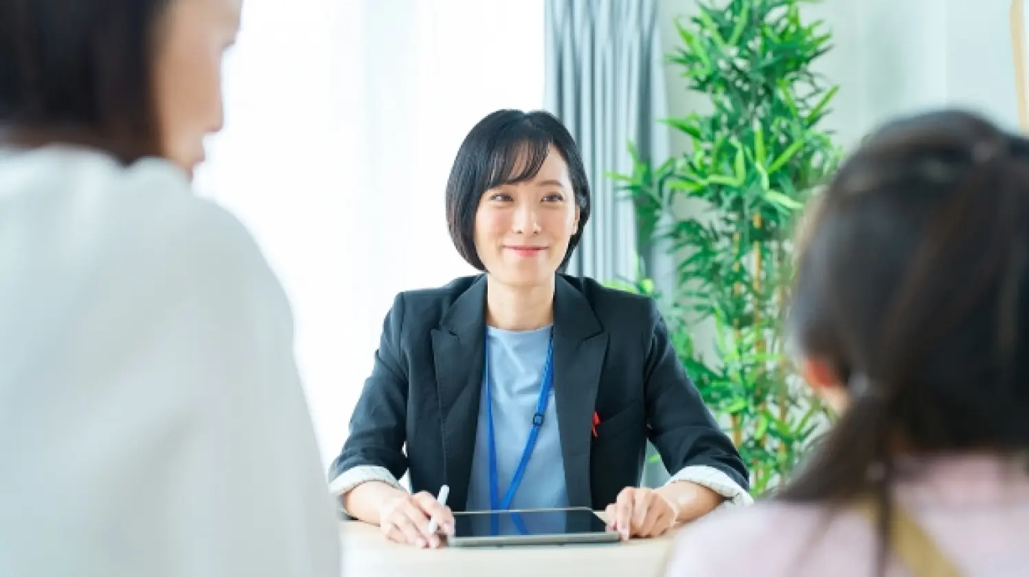 写真：家庭教師が親子の話を笑顔で聞いている