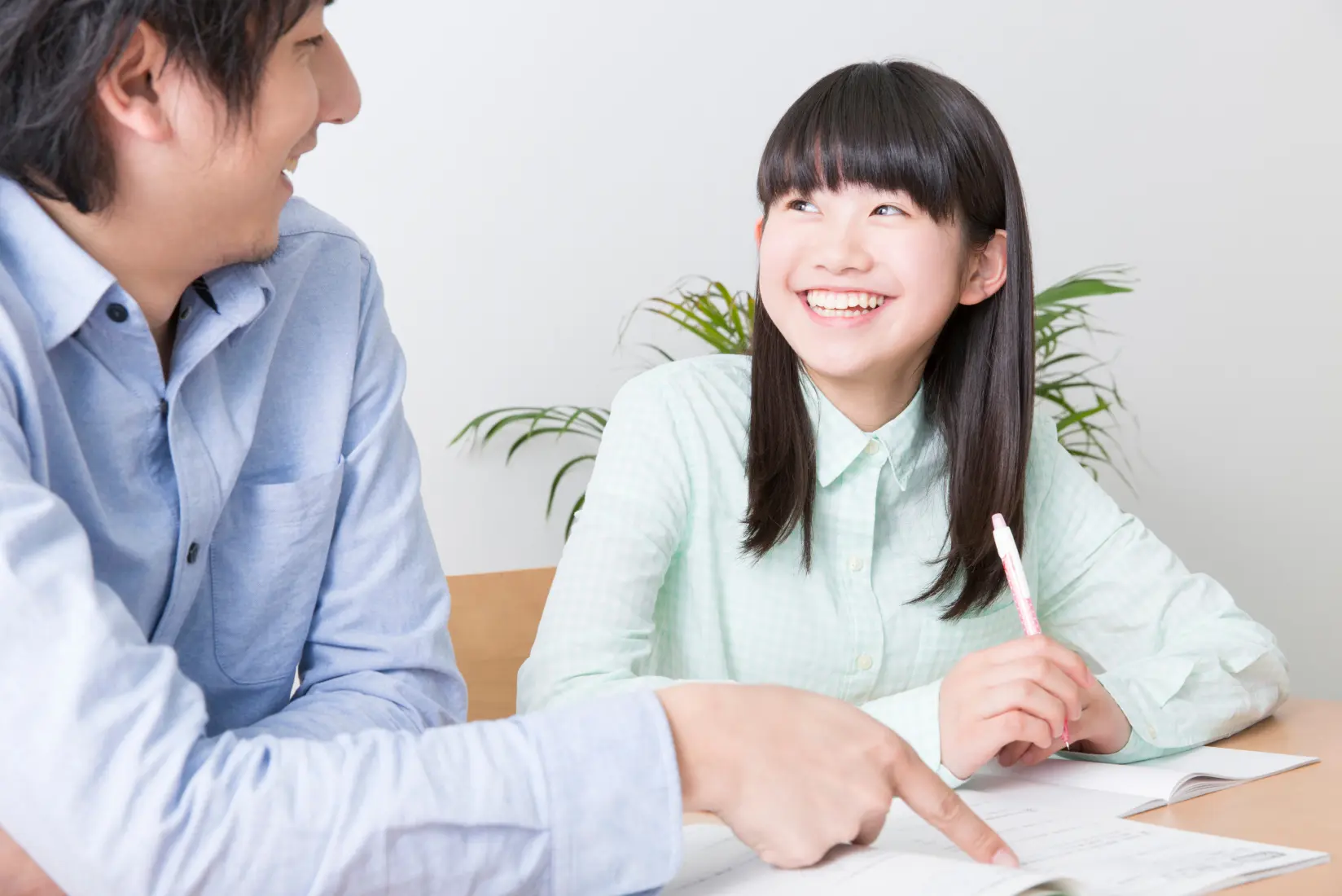 写真：家庭教師と女の子が見つめ合って笑っている